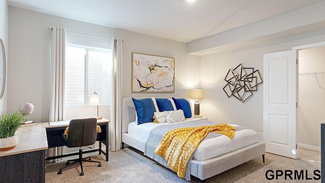 carpeted bedroom featuring a walk in closet and a closet