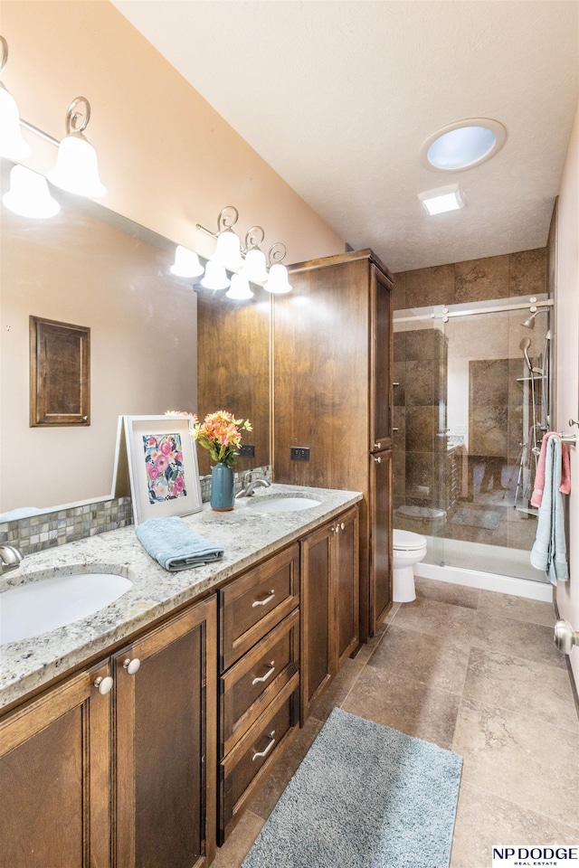 bathroom featuring vanity, toilet, and walk in shower