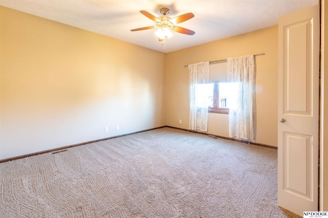 carpeted spare room with ceiling fan