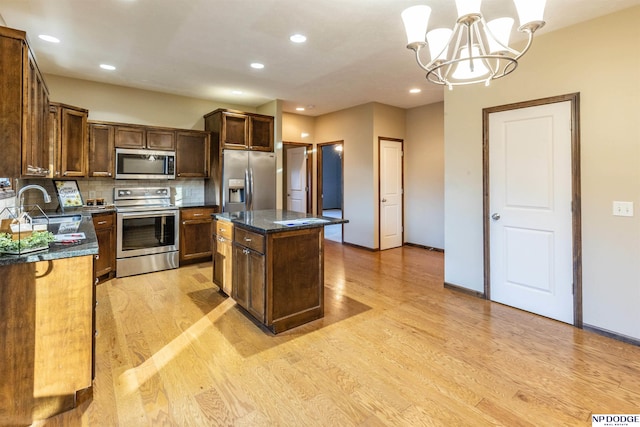 kitchen featuring a center island, sink, stainless steel appliances, light hardwood / wood-style flooring, and a notable chandelier