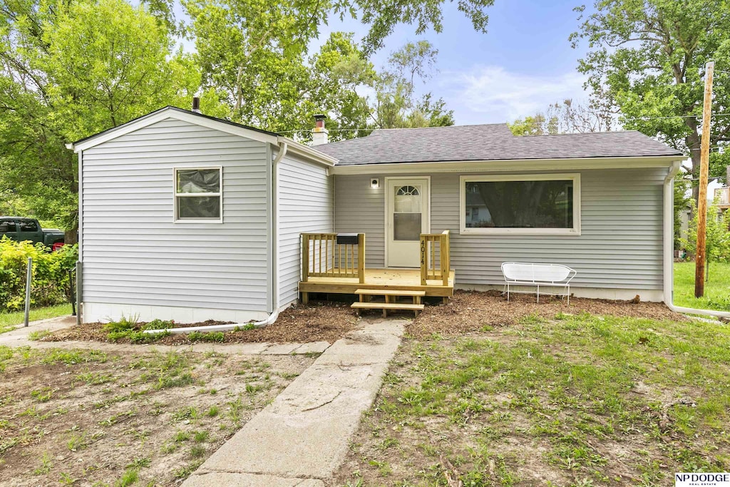 view of front facade featuring a deck and a front yard