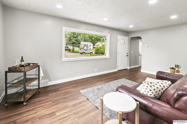 living room with dark hardwood / wood-style flooring and a textured ceiling