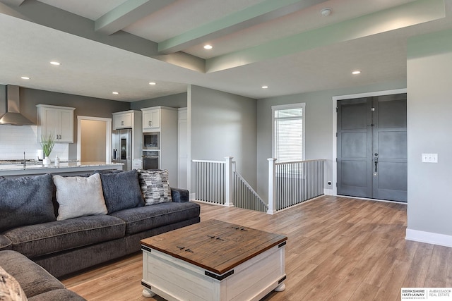 living room with beamed ceiling and light hardwood / wood-style floors