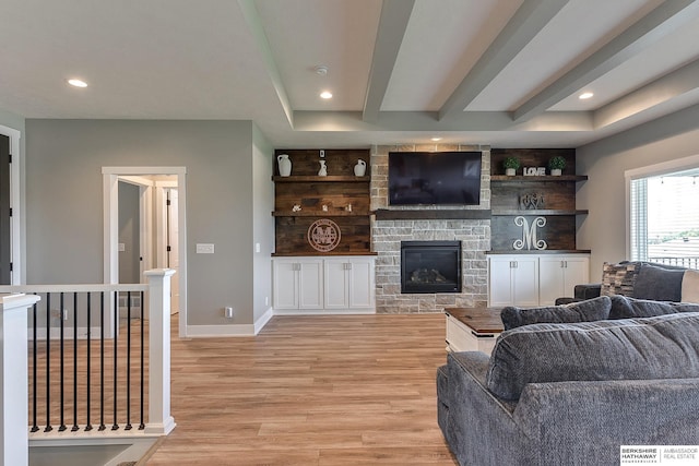 living room with a stone fireplace and light hardwood / wood-style floors