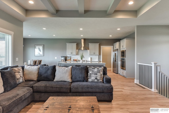 living room featuring beam ceiling and light hardwood / wood-style floors