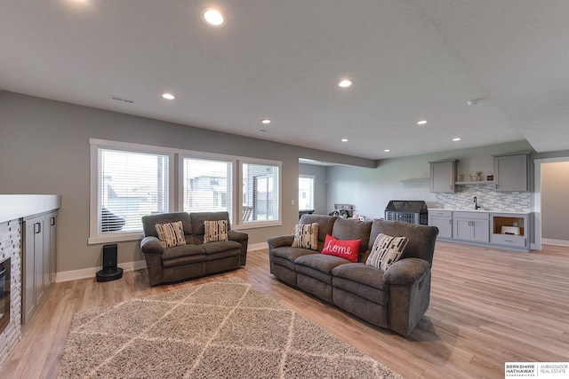 living room featuring light hardwood / wood-style flooring and sink