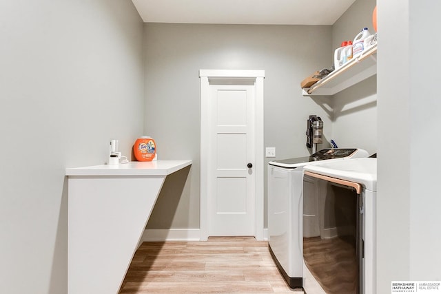 clothes washing area with washer and clothes dryer and light wood-type flooring