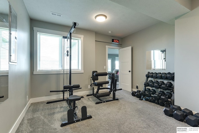 workout room with carpet floors and a textured ceiling