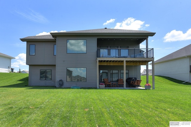 rear view of property with a balcony and a yard