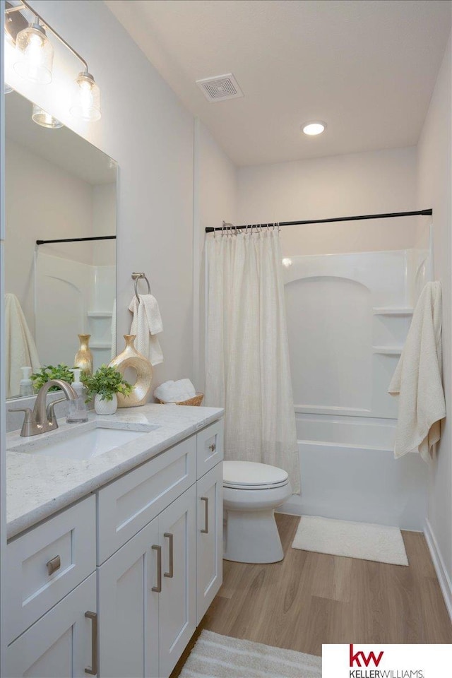 full bathroom featuring hardwood / wood-style flooring, vanity, toilet, and shower / bathtub combination with curtain