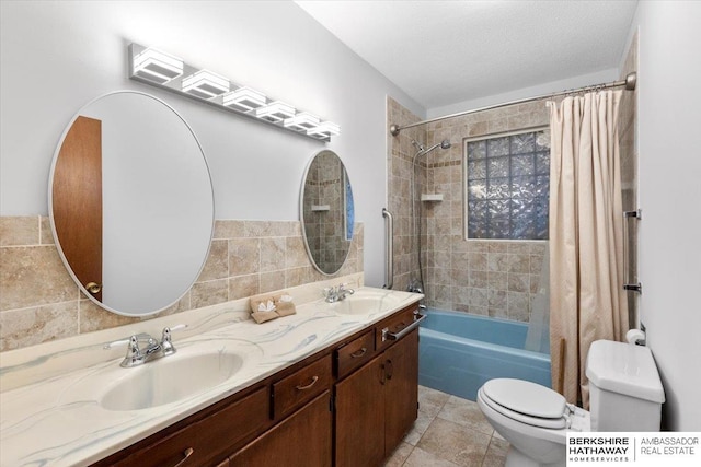 full bathroom featuring tile patterned floors, shower / bath combination with curtain, toilet, vanity, and tile walls