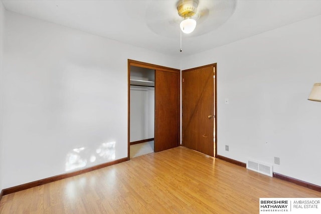 unfurnished bedroom featuring ceiling fan, light hardwood / wood-style floors, and a closet