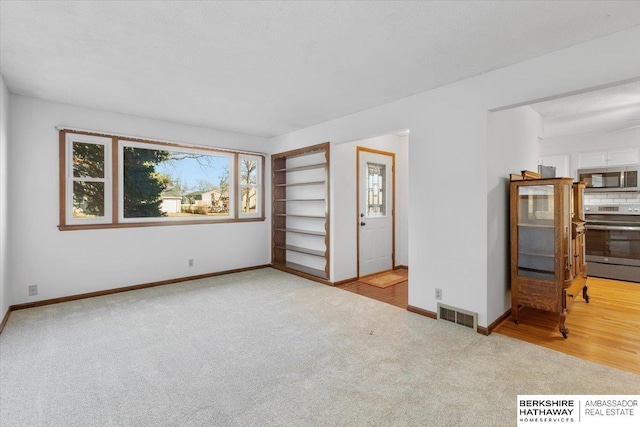 unfurnished room with light colored carpet