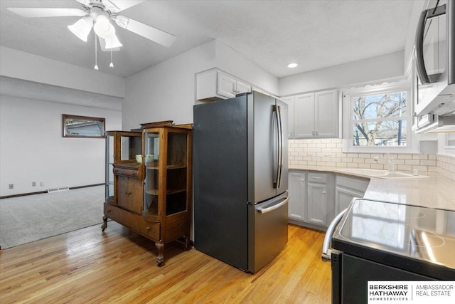 kitchen featuring light hardwood / wood-style flooring, white cabinets, stainless steel appliances, and sink