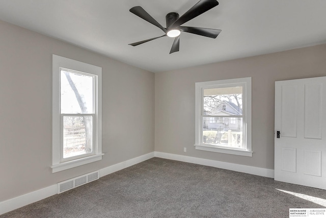 carpeted spare room featuring ceiling fan