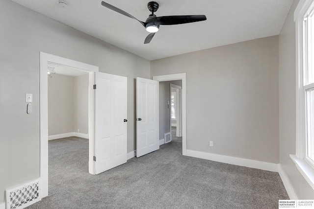 unfurnished bedroom with ceiling fan and light colored carpet