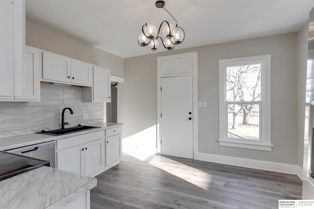 kitchen featuring white cabinetry, sink, hanging light fixtures, tasteful backsplash, and light wood-type flooring