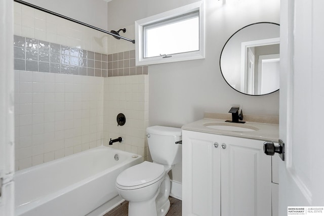 full bathroom featuring hardwood / wood-style floors, vanity, tiled shower / bath combo, and toilet