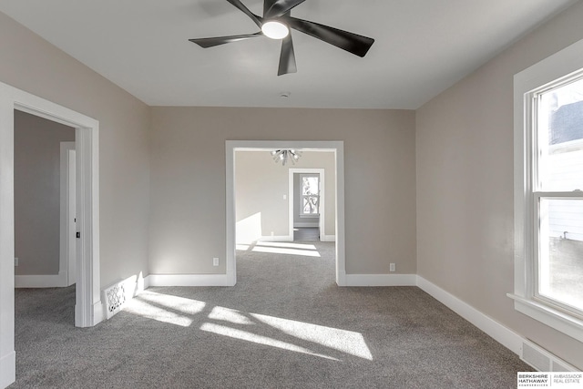 empty room featuring carpet flooring, ceiling fan, and a healthy amount of sunlight