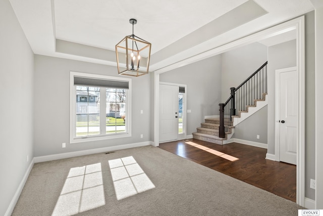 foyer entrance with dark hardwood / wood-style floors and an inviting chandelier