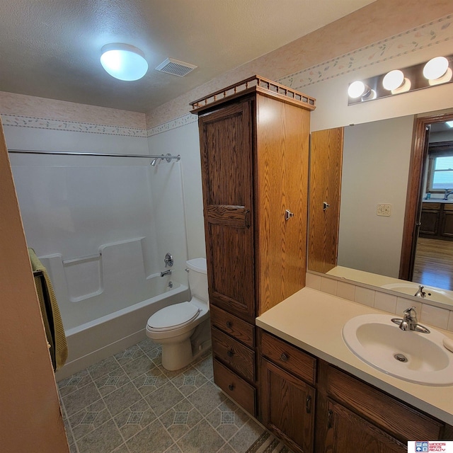 full bathroom featuring a textured ceiling, vanity, toilet, and shower / bathtub combination