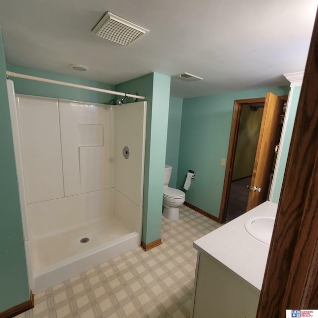 bathroom with vanity, toilet, and a shower