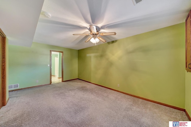 spare room featuring light carpet and ceiling fan