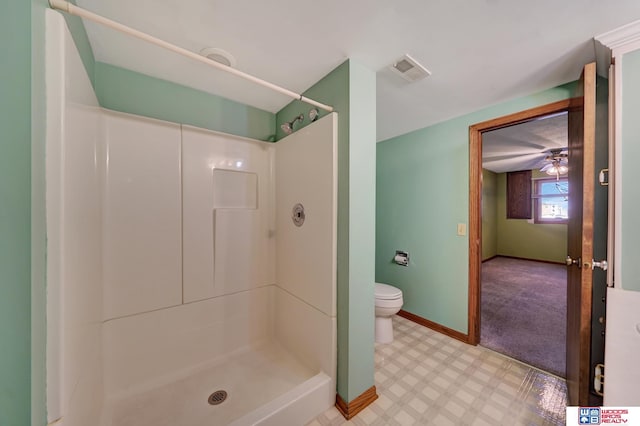 bathroom with a shower, ceiling fan, and toilet