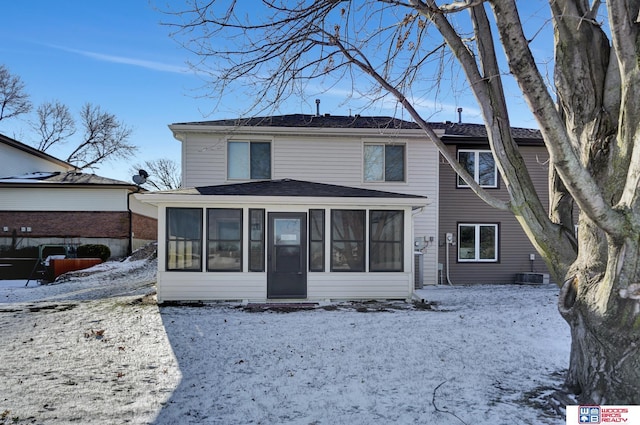 view of front of home featuring a sunroom and cooling unit