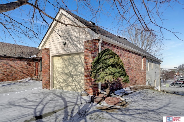 snow covered property featuring a garage