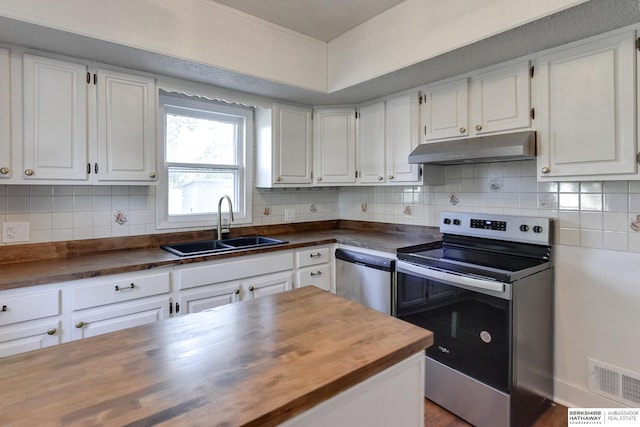 kitchen with white cabinets, stainless steel appliances, butcher block countertops, and sink