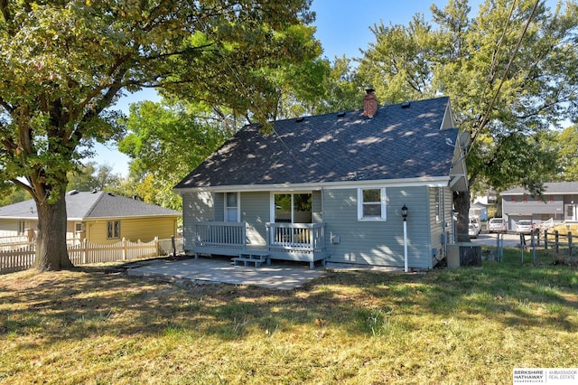 rear view of property with a patio, a wooden deck, cooling unit, and a lawn