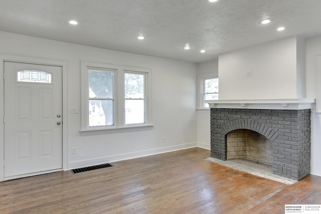 interior space with a fireplace, hardwood / wood-style floors, and a textured ceiling