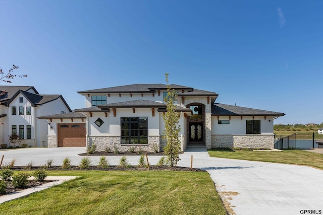 prairie-style house featuring a garage and a front lawn