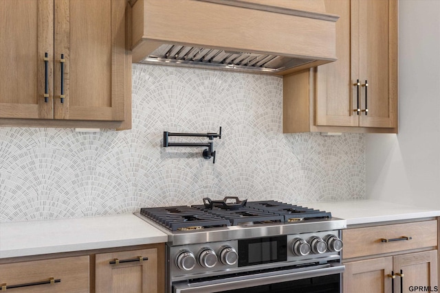 kitchen featuring backsplash, premium range hood, and stainless steel gas range