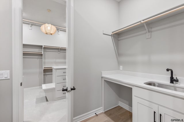 spacious closet with light wood-type flooring and sink