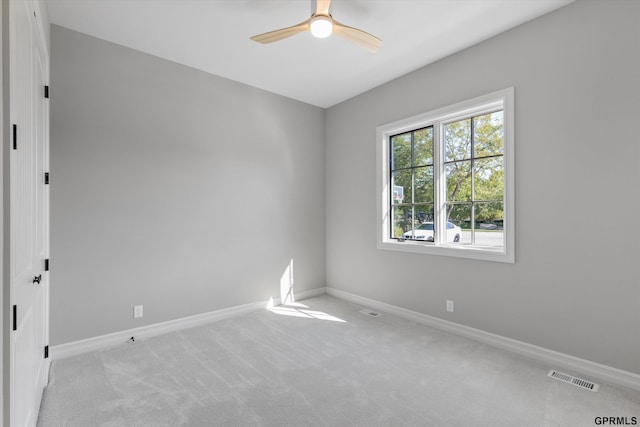 carpeted spare room with ceiling fan