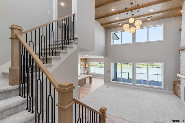 stairway featuring hardwood / wood-style floors, high vaulted ceiling, and wooden ceiling