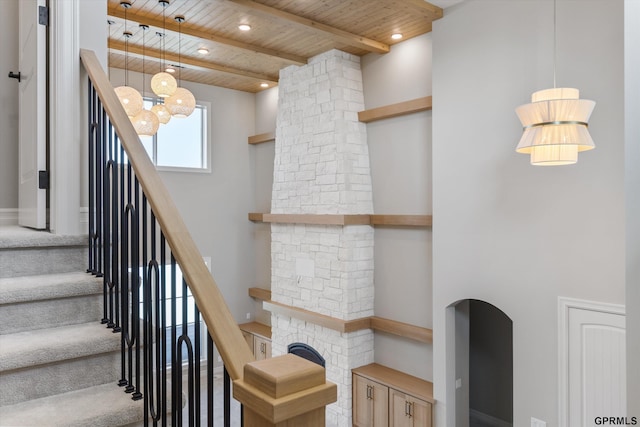 staircase with beam ceiling, wood ceiling, and a high ceiling