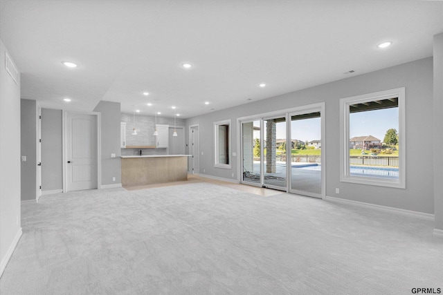 unfurnished living room featuring light colored carpet