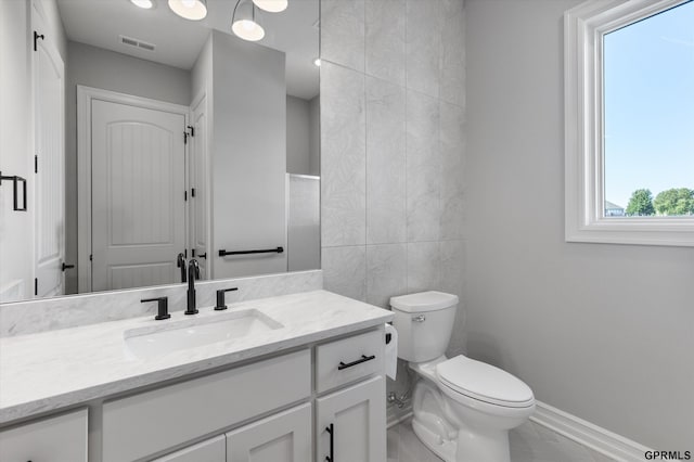 bathroom with tile patterned flooring, vanity, tile walls, and toilet