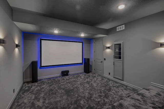 home theater with a textured ceiling and dark colored carpet