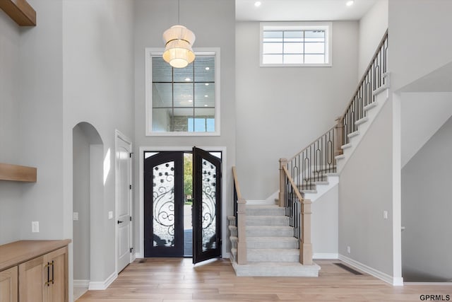 foyer featuring french doors, a high ceiling, and light hardwood / wood-style flooring