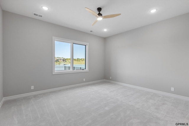 carpeted spare room featuring ceiling fan