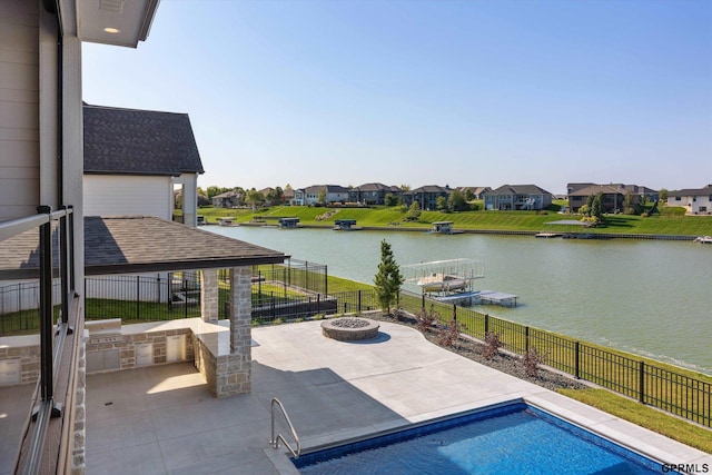 view of swimming pool with a water view, a patio, and a fire pit