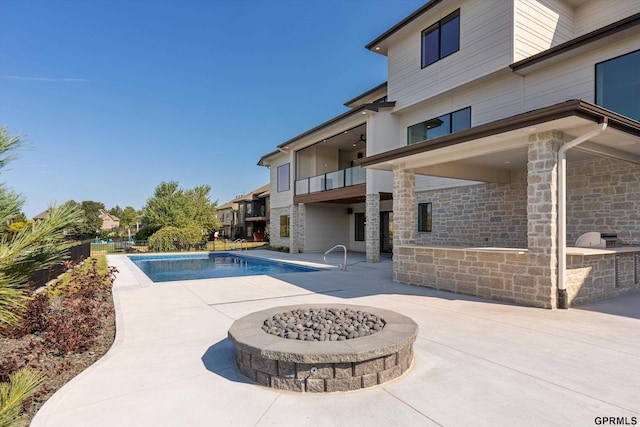 view of swimming pool with a patio area and a fire pit