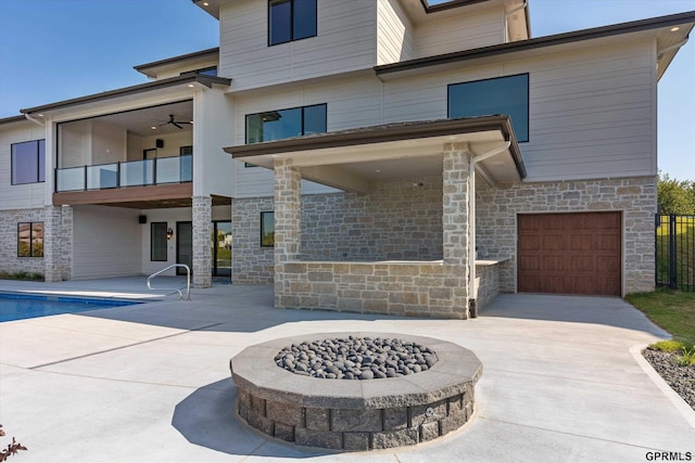 rear view of house featuring a patio, a balcony, and an outdoor fire pit