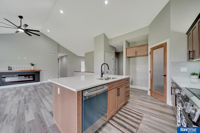 kitchen with sink, light hardwood / wood-style flooring, ceiling fan, an island with sink, and appliances with stainless steel finishes