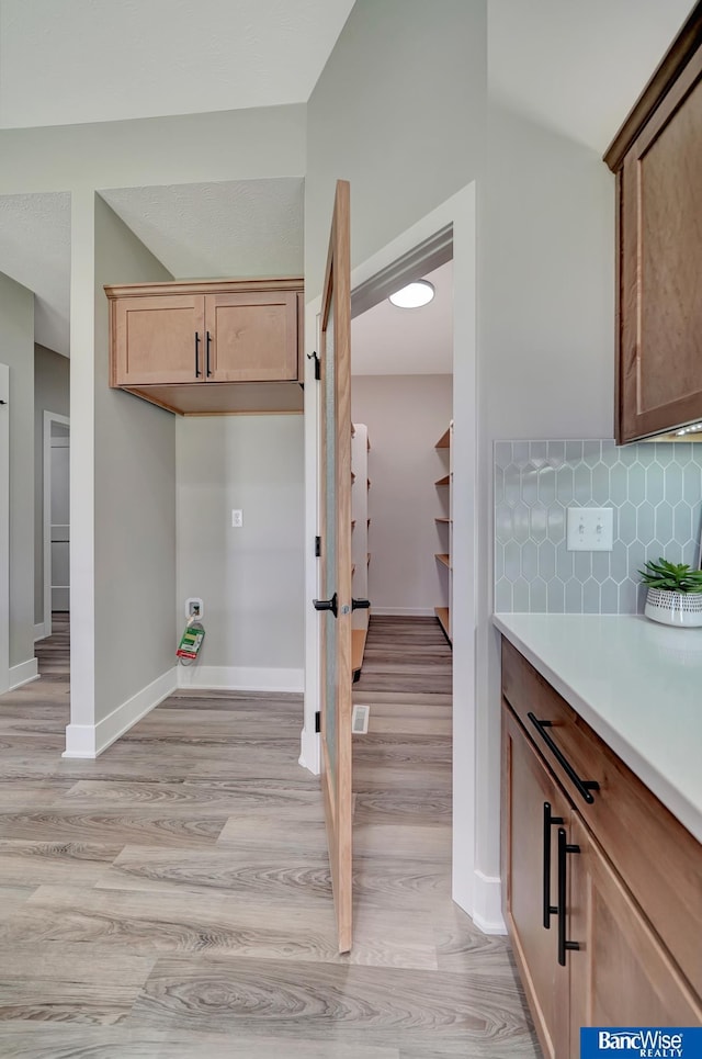 kitchen with backsplash and light hardwood / wood-style flooring