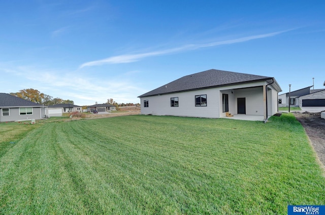 back of property with a lawn and a patio